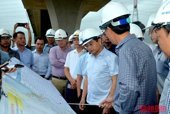 Bộ trưởng Nguyễn Văn Thắng (thứ 2 từ phải sang) nghe đại diện Ban quản lý Dự án 7 báo cáo tiến độ thi công cao tốc đoạn Vĩnh Hảo-Phan Thiết.