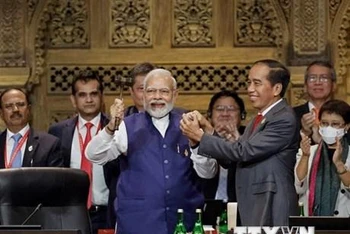 Tổng thống Indonesia Joko Widodo (phải, hàng trước) trao búa chuyển giao cương vị Chủ tịch G20 cho Thủ tướng Ấn Độ Narendra Modi (trái, hàng trước) tại Lễ bế mạc Hội nghị thượng đỉnh G20 ở Bali (Indonesia), ngày 16/11. (Ảnh: AFP/TTXVN)