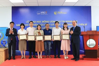 Lãnh đạo Đại học Quốc gia Hà Nội trao học bổng ươm tạo tài năng trẻ. (Ảnh: NGỌC DIỆP)