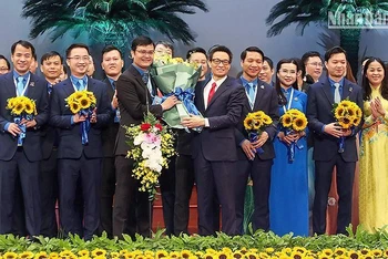 Phó Thủ tướng Vũ Đức Đam trao những bó hoa tươi thắm tặng Bí thư thứ nhất Trung ương Đoàn khóa XII Bùi Quang Huy và các đồng chí trong Ban Chấp hành Trung ương Đoàn khóa XII.