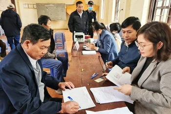 Các hộ dân xã Thanh Xuân ký nhận tiền đền bù giải phóng mặt bằng dự án đường Vành đai 4. (Ảnh: Hoàng Sơn)