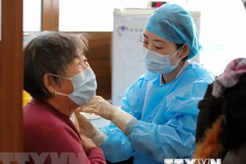 Nhân viên y tế tiêm vaccine phòng Covid-19 cho người dân tại tỉnh Sơn Đông, Trung Quốc. (Ảnh: AFP/TTXVN)