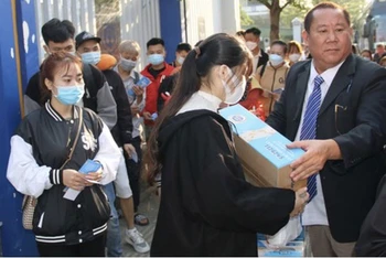 Các sinh viên, người lao động nhận quà Tết trước khi lên xe về quê vào ngày 25 tháng Chạp.