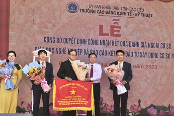 Đại diện Ủy ban nhân dân tỉnh Bạc Liêu tặng cờ thi đua xuất sắc cho Trường cao đẳng Kinh tế - Kỹ thuật Bạc Liêu. (Ảnh: TRỌNG DUY)
