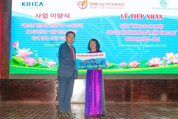 Đại diện Tổ chức Merry Year International (Hàn Quốc) trao bảng tượng trưng hỗ trợ dự án. 