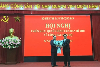 Đồng chí Mai Văn Chính trao quyết định và tặng hoa chúc mừng đồng chí Phạm Minh Tuấn được giao nhiệm vụ mới.