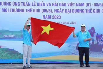 Đại diện Sở Tài nguyên và Môi trường Bình Thuận trao cờ Tổ quốc cho ngư dân đảo Phú Quý. (Ảnh: Hữu Tri)