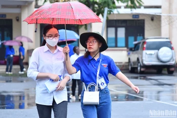 Lực lượng thanh niên tình nguyện hỗ trợ thí sinh tại khu vực điểm thi trong điều kiện thời tiết không thuận lợi trên địa bàn thành phố Hà Giang sáng 28/6.