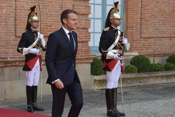 Tổng thống Pháp Emmanuel Macron đi ngang qua các vệ binh đứng gác bên ngoài Điện Elysee. (Ảnh: Getty Images)