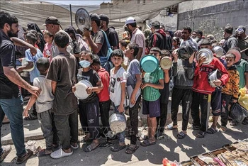 Người dân Palestine chờ nhận thực phẩm cứu trợ tại Deir el-Balah, miền trung Dải Gaza ngày 13/5/2024. Ảnh: AFP/TTXVN