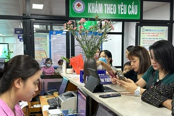 Người bệnh thao tác thanh toán không sử dụng tiền mặt tại Bệnh viện đa khoa Nông nghiệp.