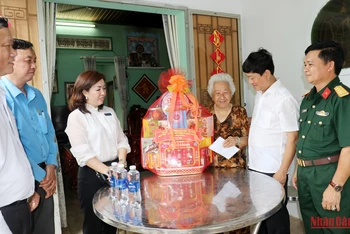 Đồng chí Võ Văn Minh, Phó Bí thư Tỉnh ủy, Chủ tịch UBND tỉnh Bình Dương (thứ hai, bên phải) thăm hỏi, tặng quà cho bà Nguyễn Thị Kiểu, mẹ liệt sĩ.