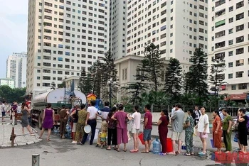 Ảnh tư liệu: Người dân xếp hàng lấy nước sạch ở chung cư HH Linh Đàm, Hoàng Liệt, Hoàng Mai, Hà Nội.