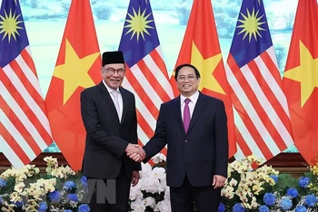 Thủ tướng Phạm Minh Chính và Thủ tướng Malaysia Anwar Ibrahim chụp ảnh chung. (Ảnh: Dương Giang/TTXVN)
