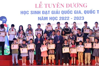 Đồng chí Phạm Tất Thắng và đồng chí Ngọ Duy Hiểu trao khen thưởng cho các em học sinh.