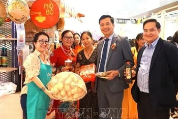 Đại sứ Đinh Ngọc Linh (thứ hai bên phải), Tham tán Lê Phú Cường (ngoài cùng bên phải) và bà Trần Thị Chang, Chủ tịch Hội hữu nghị Malaysia-Việt Nam (thứ hai bên trái) chụp ảnh kỷ niệm tại một quầy hàng giới thiệu ẩm thực Việt. (Ảnh: TTXVN)