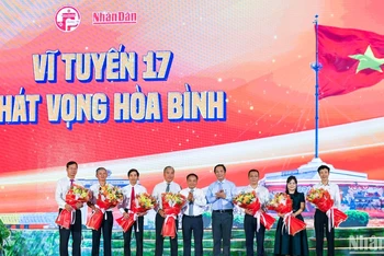 Ban tổ chức chương trình tặng hoa cho đại diện các nhà tài trợ, nhà hảo tâm. (ẢNH: THÀNH ĐẠT)