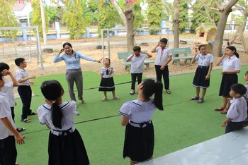 Cô giáo Nguyễn Thị Năng giảng dạy cách thể hiện ngôn ngữ bằng các ký hiệu tạo hình từ hai bàn tay cho học sinh bị khiếm thính tại Trung tâm Hỗ trợ phát triển giáo dục hòa nhập tỉnh Ninh Thuận.