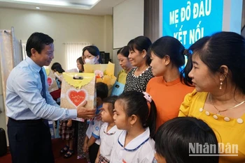 Lãnh đạo Ủy ban nhân dân tỉnh Long An trao hoa cho các mẹ đỡ đầu và quà cho trẻ mồ côi. 
