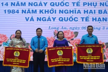 Chủ tịch Liên đoàn Lao động Long An Nguyễn Văn Quí tặng cờ thi đua cho 3 tập thể “Giỏi việc nước, đảm việc nhà”.
