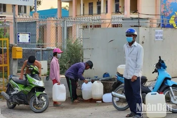 Người dân vùng hạ tranh thủ lấy nước ngọt từ đơn vị cung cấp nước chở bằng xe bồn hỗ trợ về sử dụng qua ngày.