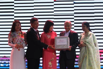 Đại diện Sở Du lịch Thành phố Hồ Chí Minh tặng quà cho đại diện đoàn khách MICE đến từ Ấn Độ (Ảnh: TTXVN) 