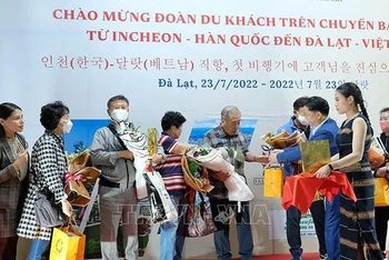 Đại diện Sở Văn hóa, Thể thao và Du lịch Lâm Đồng tặng hoa chúc mừng những du khách quốc tế đầu tiên đến Đà Lạt hôm 23/7. (Ảnh: TTXVN) 