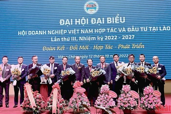 Đại sứ Nguyễn Bá Hùng và Thứ trưởng Công thương Lào tặng hoa chúc mừng Ban Chấp hành Hội Doanh nghiệp Việt Nam tại Lào khóa III, nhiệm kỳ 2022-2027. (Ảnh: Quốc Dũng)