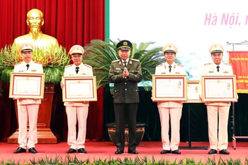 Bộ trưởng Công an Tô Lâm trao phần thưởng của Đảng Nhà nước cho cán bộ Công an thành phố có thành tích xuất sắc.