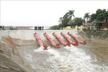 Lấy nước đổ ải tại Trạm bơm Thanh Điềm, xã Thanh Điềm, huyện Mê Linh (Hà Nội). (Ảnh minh họa: TTXVN) 