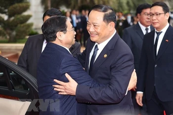 Thủ tướng Lào Sonexay Siphandone đón Thủ tướng Phạm Minh Chính. (Ảnh: Dương Giang/TTXVN) 