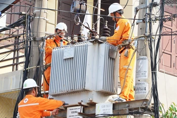 Công nhân Công ty Điện lực Quảng Bình thay máy biến áp chống quá tải hệ thống điện.