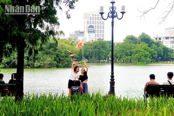 Du khách nước ngoài chụp ảnh tại Hồ Gươm, Hà Nội (Ảnh: T.LINH)