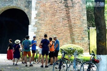 Khách du lịch nước ngoài theo tour tham quan Hà Nội bằng xe đạp tại thành Cửa Bắc trên phố Phan Đình Phùng. (Ảnh: T.LINH)