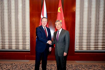 Bộ trưởng Ngoại giao Trung Quốc Vương Nghị (phải) bắt tay Ngoại trưởng Anh David Cameron trong cuộc gặp bên lề Hội nghị An ninh Munich, ngày 16/2/2024. (Nguồn: China Daily)