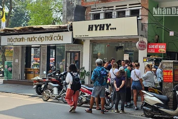 Khách du lịch nước ngoài đứng xếp hàng chờ mua bánh mì tại một cửa hàng nhỏ trên phố Lý Quốc Sư, Hà Nội. (Ảnh: T.LINH)
