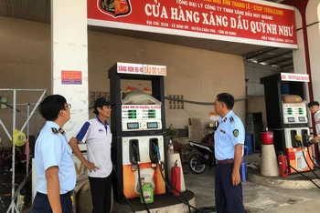 Lực lượng chức năng kiểm tra một cửa hàng xăng dầu tại tỉnh An Giang. 
