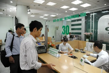 Khách hàng giao dịch tại Ngân hàng TMCP Ngoại thương Việt Nam. (Ảnh HẢI THANH)