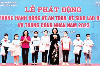 Lãnh đạo Bộ Lao động-Thương binh và Xã hội và UBND thành phố Hà Nội trao quà tặng con đoàn viên công đoàn có hoàn cảnh khó khăn, bị tai nạn lao động. (Ảnh TRẦN OANH)