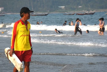 Ông Đặng Cư, một nhân viên cứu hộ lâu năm, chăm chú quan sát bao quát khu vực biển du khách đang tắm.