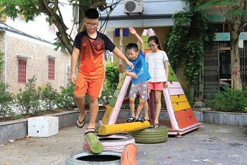 Trẻ em vui chơi tại sân chơi làm từ vật liệu tái chế do nhóm Think Playgrounds xây dựng trên địa bàn phường Việt Hưng, quận Long Biên, Hà Nội. (Ảnh Quang Thái)