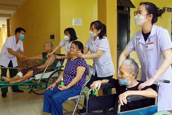 Các y, bác sĩ Bệnh viện Quân y 4 thuộc Cục Hậu cần Quân khu 4 xoa bóp, trị liệu cho các thương binh tại Trung tâm Điều dưỡng thương binh tỉnh Nghệ An.