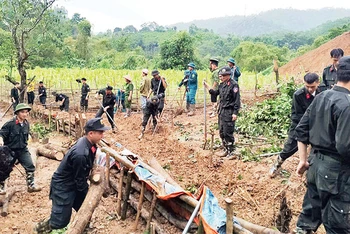 Các chiến sĩ Công an tỉnh Bắc Kạn giúp người dân xã Quang Thuận, huyện Bạch Thông khắc phục hậu quả sạt, lở đất. (Ảnh THÙY DƯƠNG)