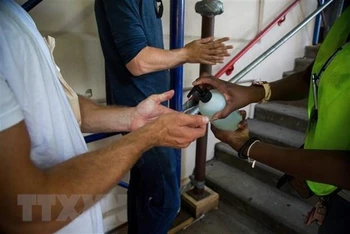 Người dân khử khuẩn tay tại một điểm tiêm vaccine phòng bệnh đậu mùa khỉ. (Ảnh: THX/TTXVN) 