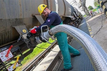 Công nhân vận hành ống dẫn nhiên liệu lỏng tại cơ sở lọc dầu ở thị trấn Szazhalombatta, Hungary. (Ảnh: AFP/TTXVN) 