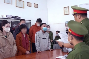 Công an tỉnh Lâm Đồng tống đạt quyết định khởi tố bị can Nguyễn Xuân Đạt và Phạm Thị Hoa. (Ảnh: Công an tỉnh Lâm Đồng cung cấp)