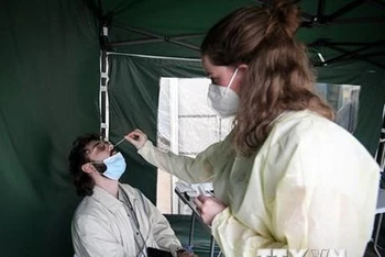 Nhân viên y tế lấy mẫu xét nghiệm Covid-19 cho người dân tại Paris, Pháp. (Ảnh: AFP/TTXVN)