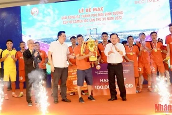 Chủ tịch Hội đồng quản trị Tổng Công ty Becamex IDC Nguyễn Văn Hùng (bên phải, hàng đầu) trao Cúp vô địch cho đội Bambo FC.