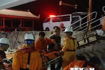 Đưa nạn nhân gặp nạn trên biển về bờ an toàn tại Đà Nẵng trong đêm 19/11. (Ảnh: TTXVN phát)