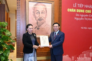 Chủ tịch Quốc hội Vương Đình Huệ tiếp nhận bức tranh chân dung Chủ tịch Hồ Chí Minh do nguyên Chủ tịch Quốc hội Nguyễn Thị Kim Ngân trao tặng. (Ảnh: Duy Linh)